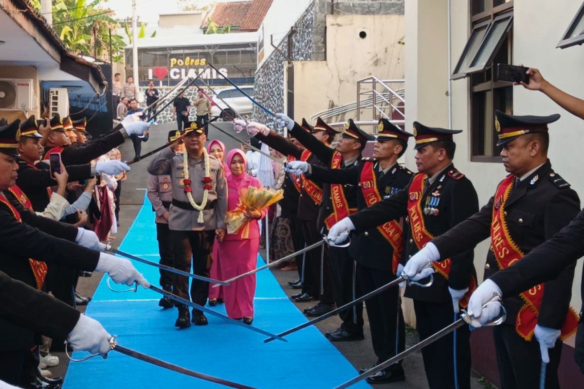 AKBP H. Hidayatullah didampingi istri serta Kapolres Ciamis AKBP Eko Iskandar mengikuti prosesi pedang pora saat pelepasan di Mapolres Ciamis, Senin (3/8/2026). Shotlist.id/Foto: YT