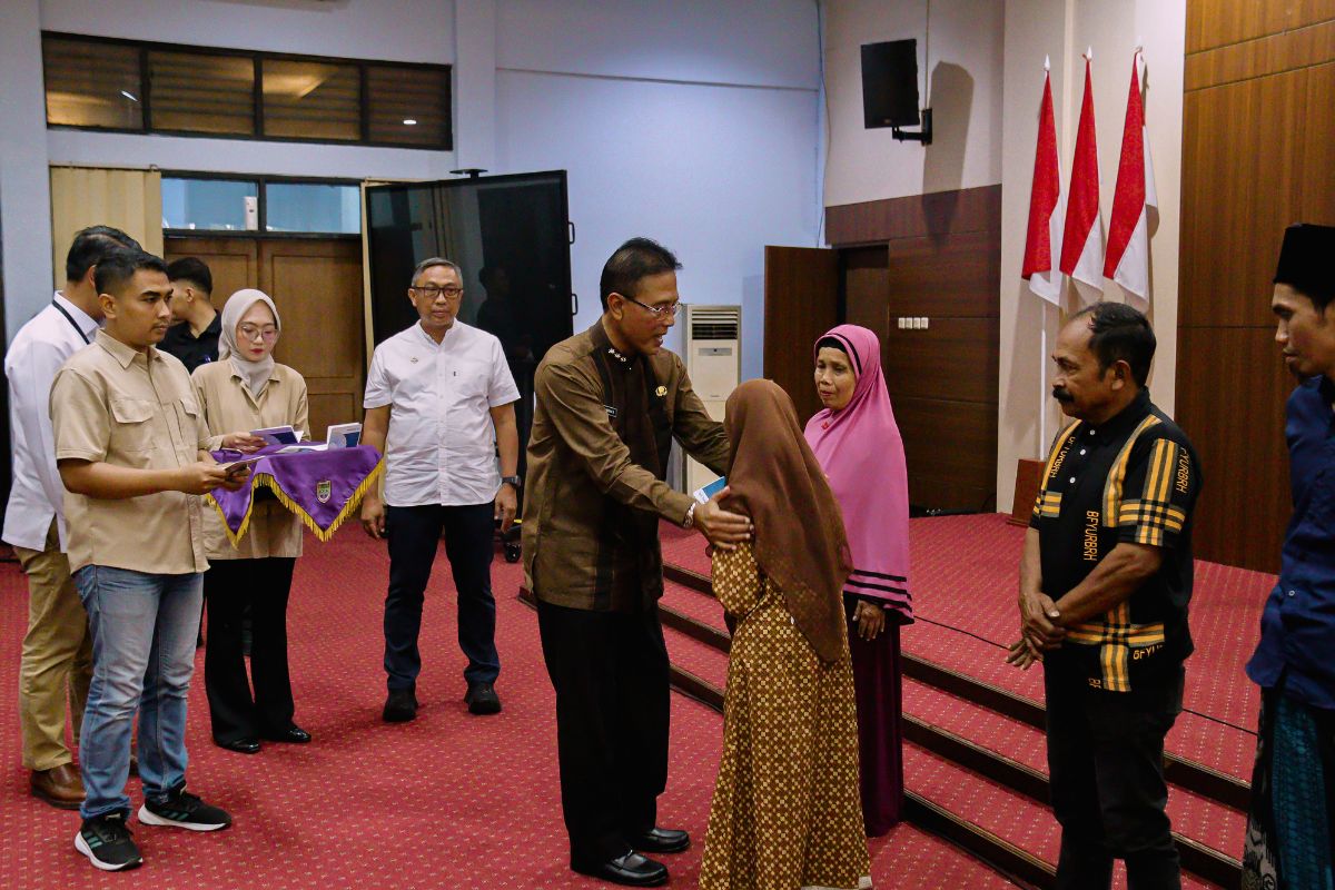 Bupati Ciamis Herdiat Sunarya menyerahkan buku tabungan BSPS kepada perwakilan penerima manfaat di Aula Setda Ciamis, Jumat (21/8/2026). Shotlist.id/Foto: FL